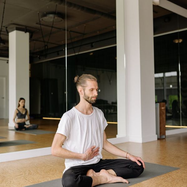 Person sitting cross-legged, deep in concentration during meditation.